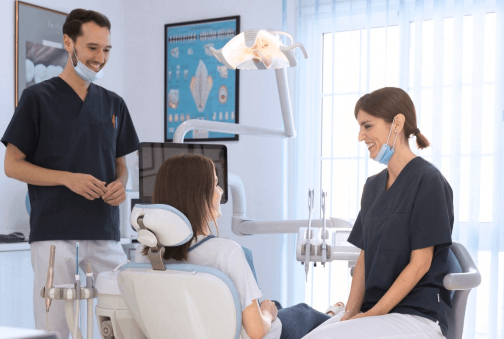 two dentist smiling at a patient lying down