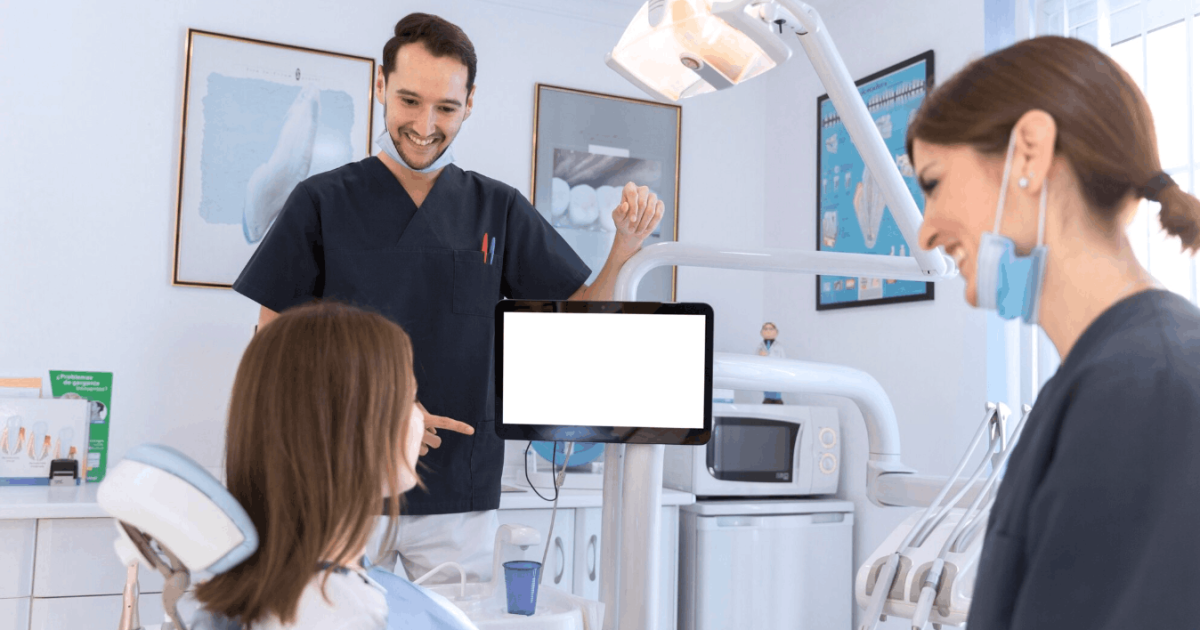 patient in treatment room with two dentist
