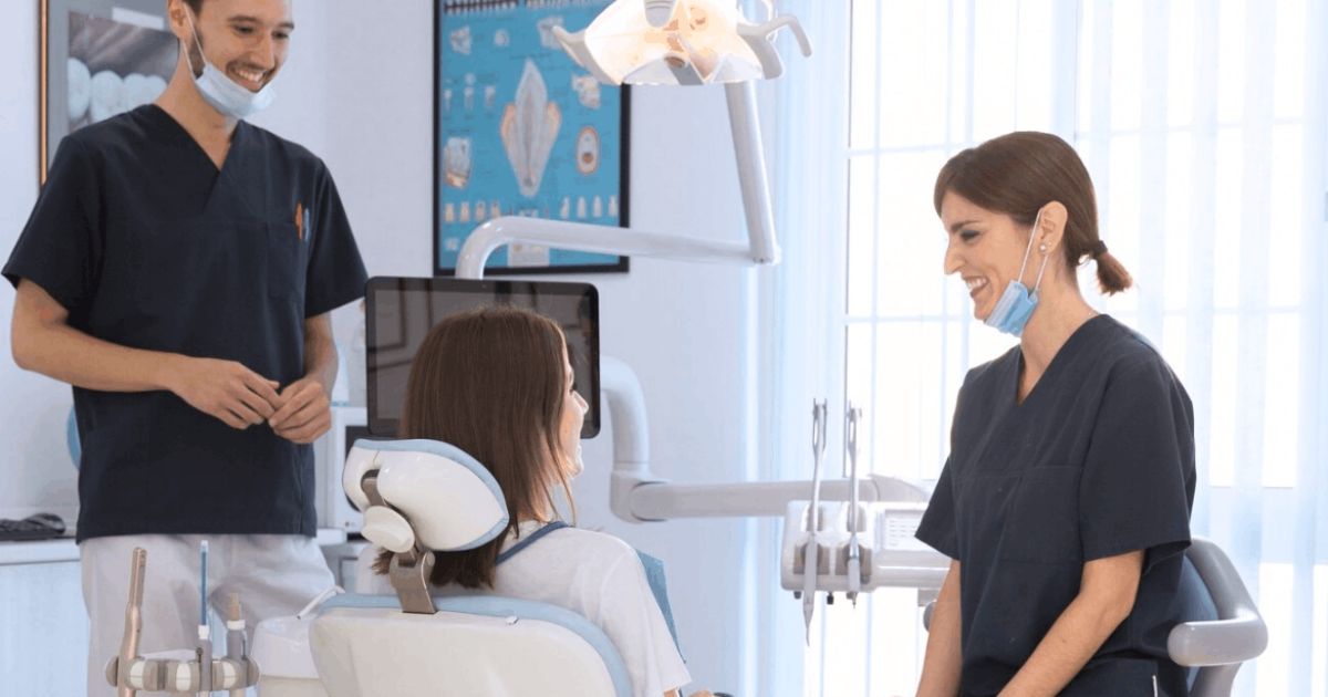 two dentist smiling at a patient lying down
